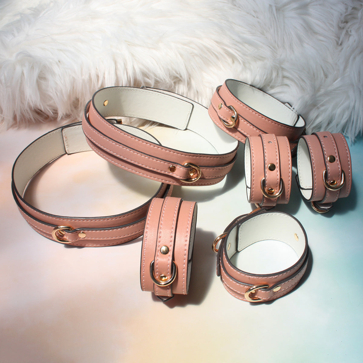 Close-up of gold-tone hardware on deep pink vegan leather wrist cuffs