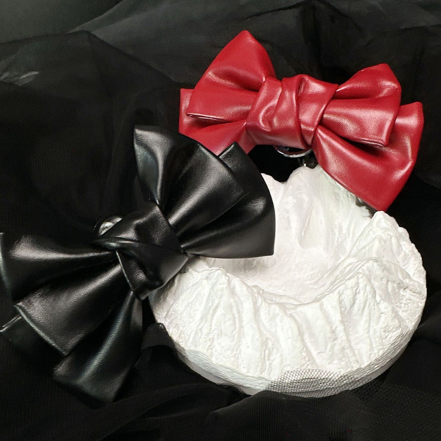 Front view of the Glossy Bow Anal Plug featuring a polished metal body and a black faux-leather ribbon, available on SexyMaker.