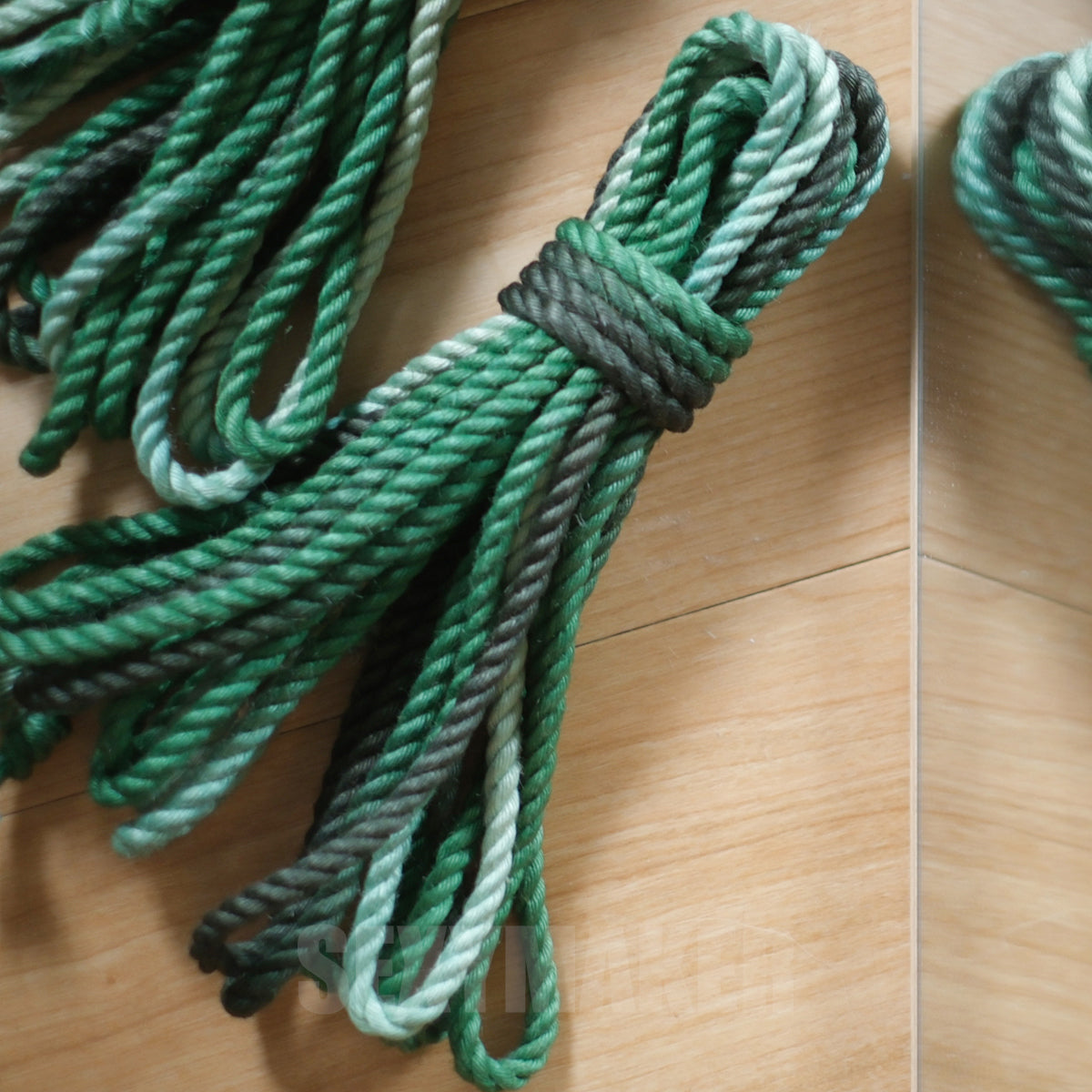 Close-up of premium treated 6mm jute Shibari rope in a dark to light green gradient for authentic Kinbaku and rope bondage by Sexy Maker.