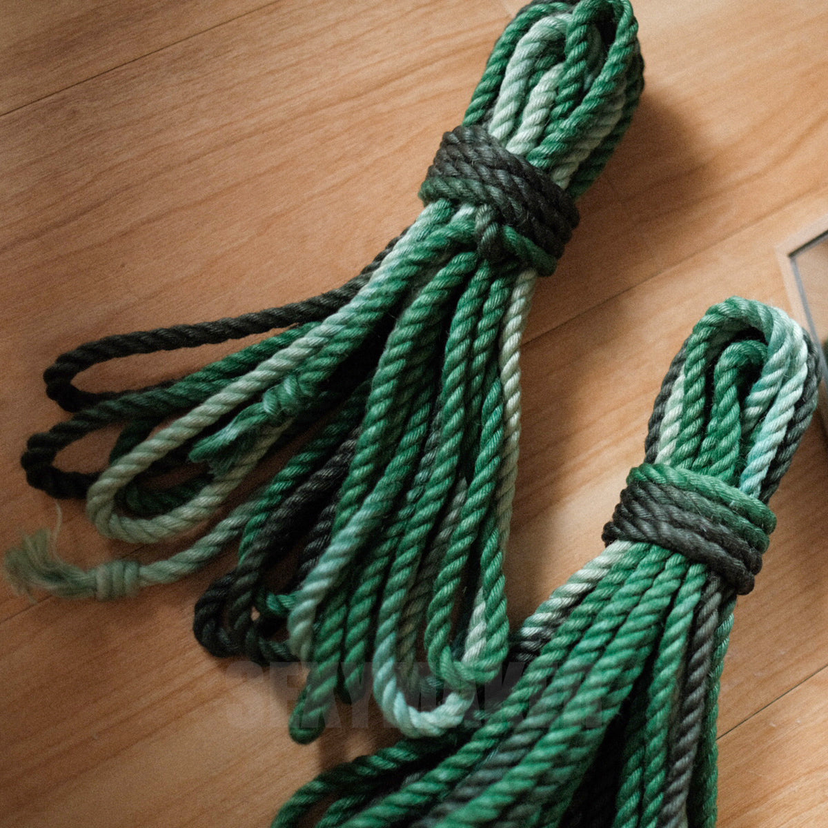 Close-up of premium treated 6mm jute Shibari rope in a dark to light green gradient for authentic Kinbaku and rope bondage by Sexy Maker.