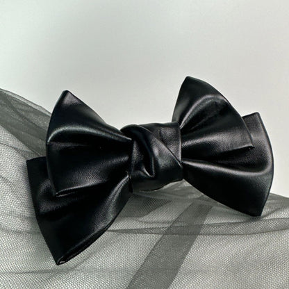 Front view of the Glossy Bow Anal Plug featuring a polished metal body and a black faux-leather ribbon, available on SexyMaker.