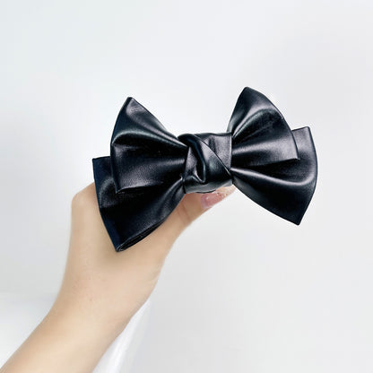 Front view of the Glossy Bow Anal Plug featuring a polished metal body and a black faux-leather ribbon, available on SexyMaker.