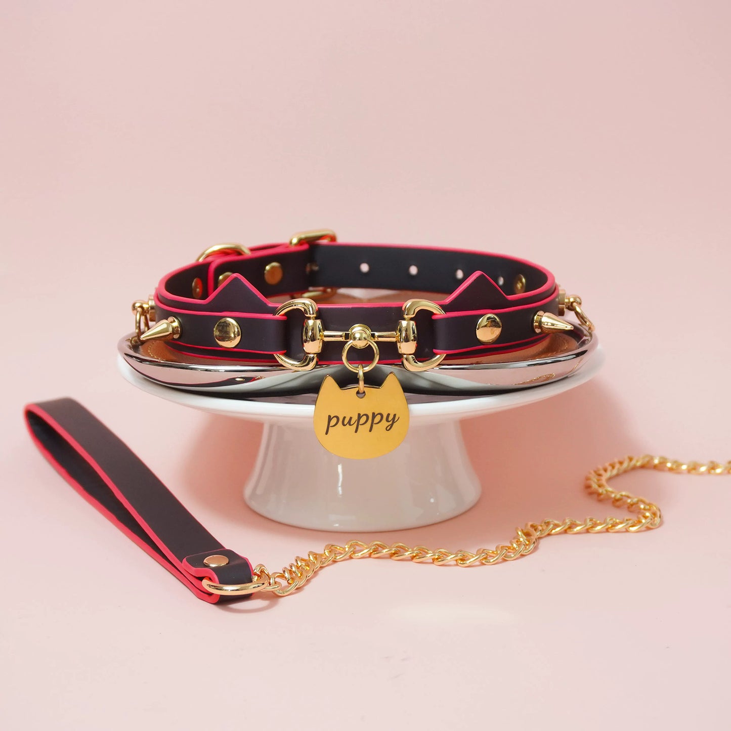 Close-up of heat-reactive color-changing black to red pet play collar featuring spiked cat ears and a gold puppy charm by Sexy Maker.