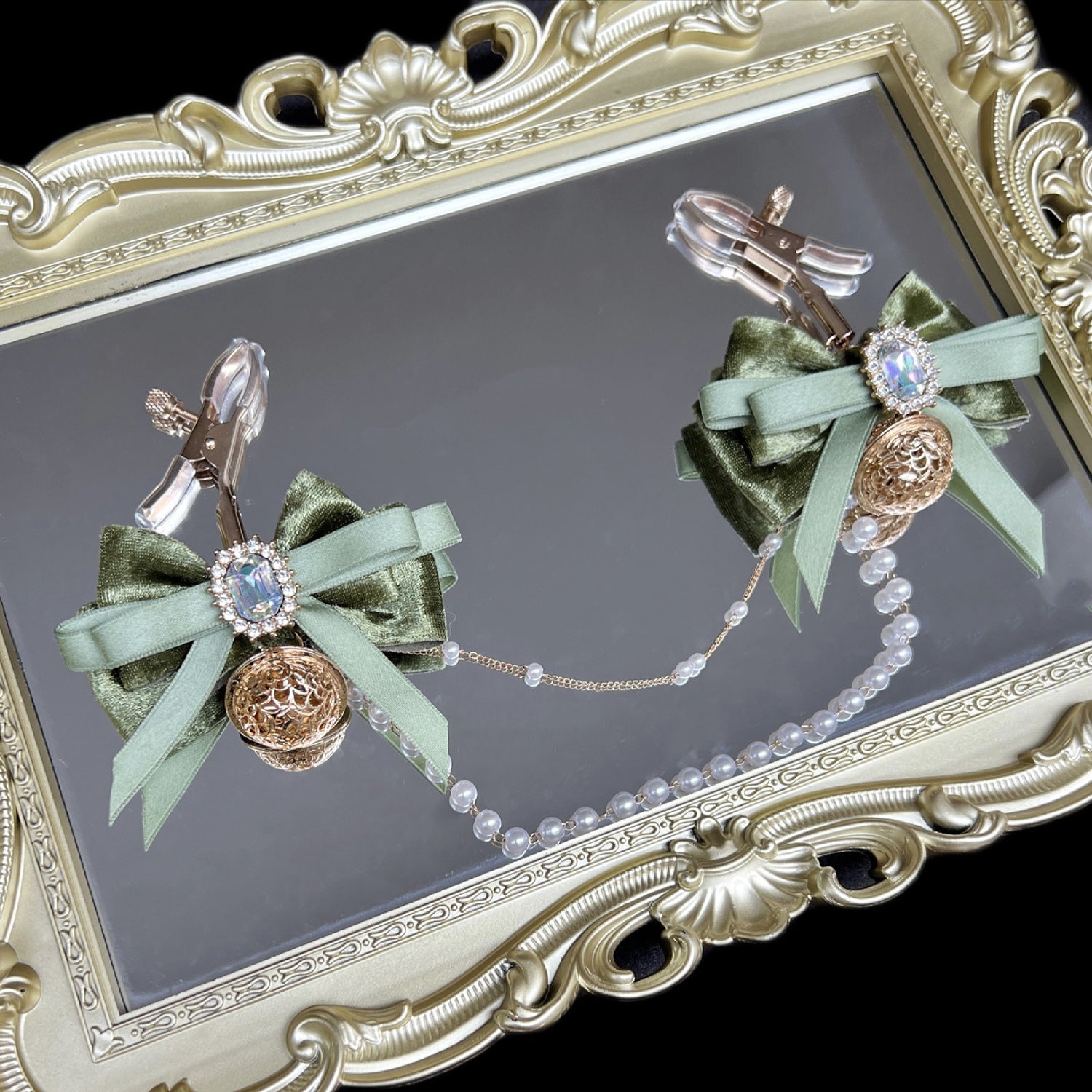 Close-up of adjustable green ribbon nipple clamps with connecting chain and sparkling stones, beginner-friendly romantic BDSM jewelry by Sexy Maker.